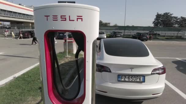Tesla Elektrikli Otomobil Şehrin Merkezindeki Modern Bir Elektrik Şarj Istasyonunda — Stok video