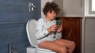 9 yaşındaki çocuk tuvalette oturup akıllı telefona bakmaktan mutlu. Sosyal ağlara ve internete olan bağımlılığı. Günlük hayatta çok fazla zaman harcıyor.