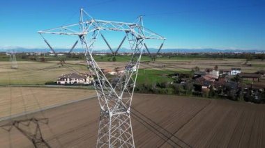 Lombardy İtalya 'da Milano' ya yakın güneş panelleri olan ev ve elektrik nakli için yüksek voltaj pilonu - yeşil devrim, gezegeni ve iklim değişikliğini koru - enerji maliyetini yükselt