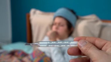 Termometresi olan hasta bir kadın ve hasta bir kadın