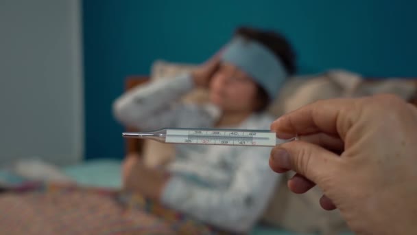Mann Mit Thermometer Und Einem Kranken Jungen Auf Dem Bett — Stockvideo