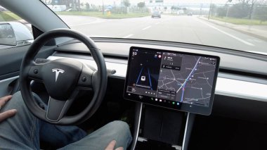 Avrupa, İtalya, Milan 12-11-2023 Otomatik pilot ve Tesla Electric araba - araba şehir trafiğinde ilerliyor, sürücü ellerini direksiyon destekli direksiyon ekranı yapay zeka ekranına koymuyor