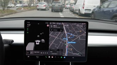 Avrupa, İtalya, Milan 12-11-2023 Otomatik pilot ve Tesla Electric araba - araba şehir trafiğinde ilerliyor, sürücü ellerini direksiyon destekli direksiyon ekranı yapay zeka ekranına koymuyor