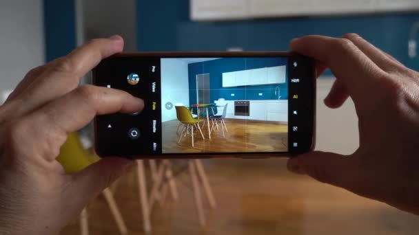 房地产摄影师在公寓客厅里的房子里用智能手机拍照和录像 与房地产经纪人一起卖房子 并在家里布置室内设计 — 图库视频影像