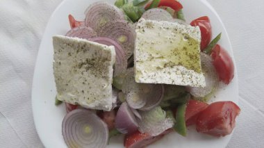 Yunan salatası, yaz aylarında domates, soğan, salatalık, biber, feta peyniri, kekik ve yağ içeren Akdeniz diyetinin tipik vejetaryen yemeği.