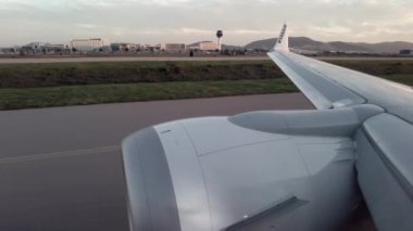 Genel kanatlar ve uçağın motoru gökyüzünde uçuyor, uçaktaki pencereden uçuşu içeriden görülebiliyor.