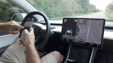 İtalya, Milan: 08.23.2024 - Tesla Electric arabadaki otomatik pilot ve otomatik sürücü özellikleri - araba geliri ve Drive Watch akıllı telefon interneti - destekli sürüş