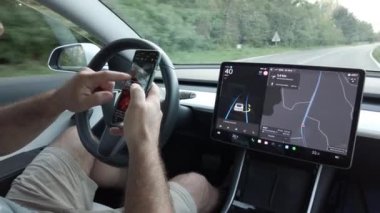 İtalya, Milan: 08.23.2024 - Tesla Electric arabadaki otomatik pilot ve otomatik sürücü özellikleri - araba geliri ve Drive Watch akıllı telefon interneti - destekli sürüş