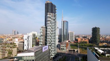 Milan, Italy: 08.28.2024 - drone view of Garibaldi Porta Nuova District in downtown of the city Gae Aulenti BAM new skyline with Unipol, UniCredit skyscrapers and Vertical Forest Bosco verticale.  clipart