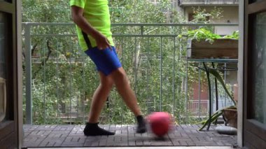 10 yaşında bir çocuk evindeki balkonda futbol oynuyor. Profesyonel futbolcu olma hayali kuruyor..