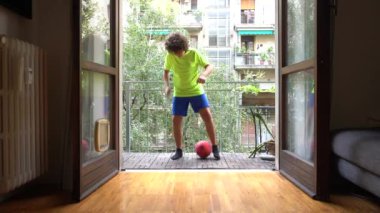 10 yaşında bir çocuk evindeki balkonda futbol oynuyor. Profesyonel futbolcu olma hayali kuruyor..