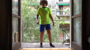 10 yaşında bir çocuk evindeki balkonda futbol oynuyor. Profesyonel futbolcu olma hayali kuruyor..