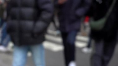 Milano 'daki şehir caddesinin bulanık bir görüntüsü. Moda haftası boyunca yaya geçitlerinden ve yoğun araba trafiğinden bir sürü insan karşıya geçiyor. Şehir merkezindeki odaklı yaşam tarzının dışında. 