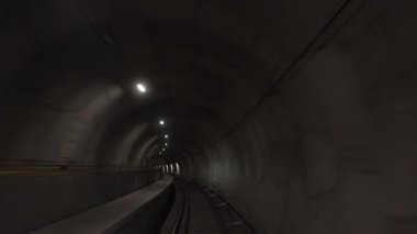 Avrupa, İtalya, Milan 02.12.2025 metro treni hızlı bir hızla yeraltı tüneline giriyor. Yeni hat 4 yer altında bir maceraya başlıyor. Kendi kendine giden vagon. 