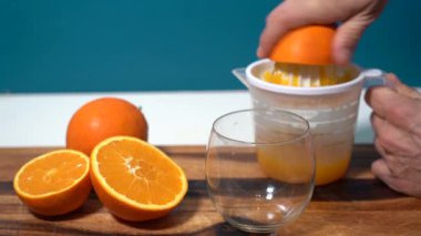 Kadın, sağlığını C vitamini, Akdeniz diyeti ve kahvaltıyla şarj etmek için ev yapımı portakal suyu hazırlıyor.