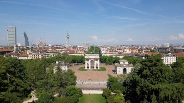 Tarihi kemer ve yeşil parkın yer aldığı güneşli şehir manzarası