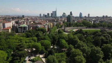 Çağdaş şehir siluetini çevreleyen yemyeşil şehir parkı ağaçları