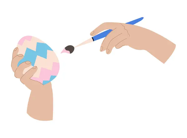 Yumurta ve fırça tutan insan elleri. Paskalya süsü. Geleneksel yumurta resmi. Beyazda izole edilmiş