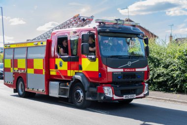 A fire engine and crew from Dorset and Wiltshire fire service arriving to attend a house fire in Swindon