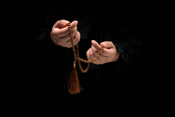 The image of a Muslim woman's hand, Islamic prayer, and her hand holding a rosary beads or tasbih.