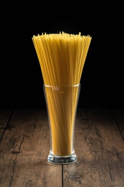 Spagetti, ahşap bir masada pişmeye hazırlanan bir bardağa konur..