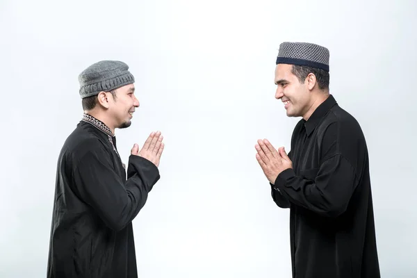 白い背景に笑顔で挨拶をする２人のアジア系ムスリム男性が立っています — ストック写真