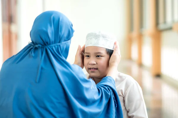 コンセプトイード ムバラク イスラーム教徒の少年が愛を持って母親を追いかけ 母親が礼拝後にモスクで帽子の世話をするのを助けた写真 — ストック写真