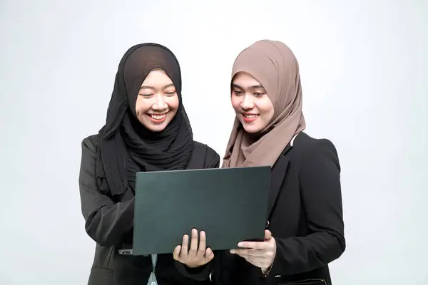 一名办公室职员 两名年轻的穆斯林妇女 带着微笑和快乐的脸 在笔记本电脑前看着工作 — 图库照片