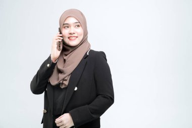 Ofis çalışanı, Asyalı Müslüman kadın cep telefonuyla konuşan, mutlu yüzlü, beyaz arka planda.