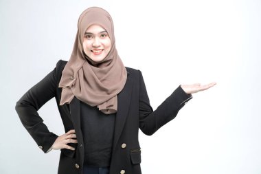 Asyalı Müslüman bir kadın için çalışan bir ofis çalışanı beyaz arka planda elle bir şey gösteriyor ve sunuyor..