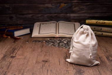 Ellerinde tahtadan bir kase pirinç taneleri ve sadaka için para torbası var. İslami sadaka kavramı. Müslümanlar yoksullara ve muhtaçlara yardım eder. Mülkiyet, gelir ve fitne için kavramsal çekim.