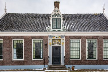Zaandam, Hollanda, 10 Şubat 2021: Zaanstad belediyesinde tarihi ahşap binaları olan Zaandam schans 'da anıtsal bir evin cephesi.