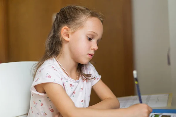 Little girl doing homework at home. High quality photo