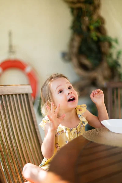 Little girl sitting outside on terrace