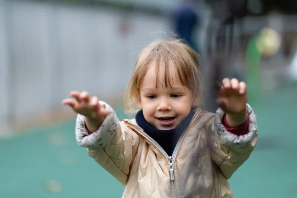 Little girl playing with swings at the playground