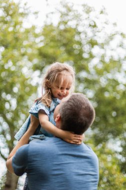 Little girl playing outside in the park with her father
