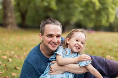 Little girl playing outside in the park with her father