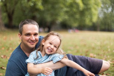 Little girl playing outside in the park with her father