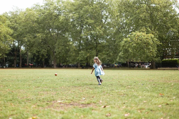 Little girl playing outside in the park with her father