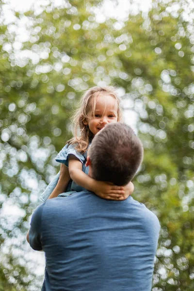 Little girl playing outside in the park with her father
