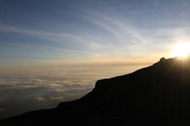 Tepelerin Uyanışı: Gün doğumu Dağ Sırtı 'nın üzerine dökülür, Altında Bulutlar Denizi' ni aydınlatır