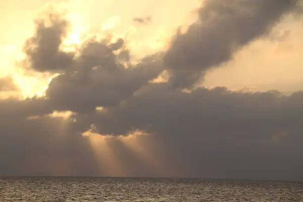 Altın ışınlar dramatik bulutları delerek güne ışık saçar..