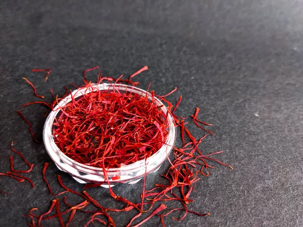 closeup picture of red saffron kept on a black background