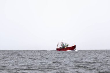 Denizde kayık, beyaz gökyüzü ve temiz deniz suyuyla