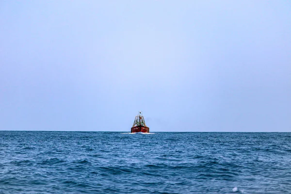 一艘红船在蔚蓝的大海中航行 天空晴朗 — 图库照片