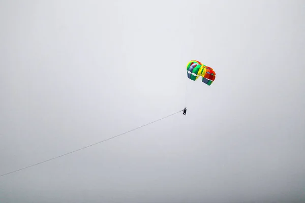白色晴朗天空中的彩色降落伞 — 图库照片