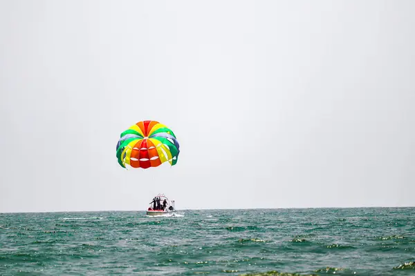 五彩斑斓的小船和滑翔伞在雪白的大海中飘扬 — 图库照片
