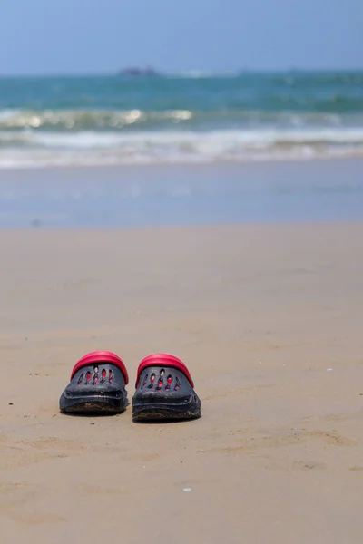 stock image black and red crooks sleepers left on the beach with waves in the background