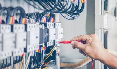 Elektrik mühendisi elektrik kontrol kabinesinin bakımını düzenli olarak test ediyor.