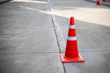 Beton yol yüzeyinde turuncu trafik konileri.